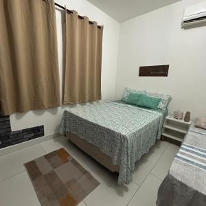 a small bedroom with a bed and a window at Recanto do Sossego in Porto Seguro