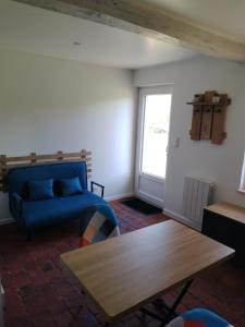 ein Wohnzimmer mit einem blauen Sofa und einem Tisch in der Unterkunft Maisonnette au calme 