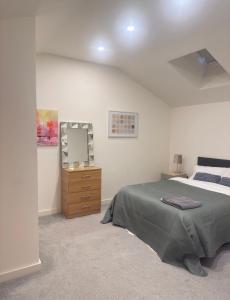 a bedroom with a bed and a dresser and a mirror at Stylish Apartment in Bradford