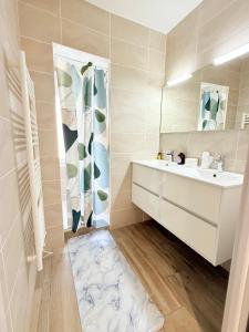 un baño con lavabo y espejo en Le Cocon Kaya T3 Wifi HD, à 10 min de La Rochelle, en Puilboreau 37 fotos más