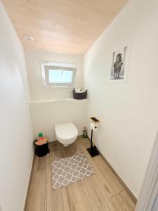 Un baño con inodoro y alfombra. en Le Cocon Kaya T3 Wifi HD, à 10 min de La Rochelle, en Puilboreau