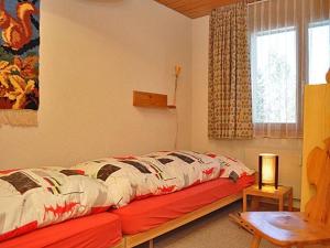 a bedroom with a bed in a room with a window at Rottal 4 Bett Wohnung in Mürren
