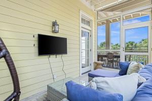 a living room with a couch and a tv on a wall at Ave 30A by Coastal Dreamin in Santa Rosa Beach
