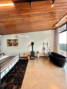 Un baño con bañera grande en una habitación con cama. en Vista espetacular, piscina e banheira no quarto!, en Maria da Fé