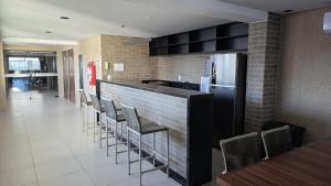 a restaurant with a bar with chairs and a refrigerator at Frente Mar Bessa João Pessoa in João Pessoa