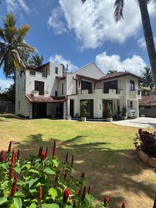 a large white house with palm trees and a yard at PereraTree in Ja-Ela +19 photos