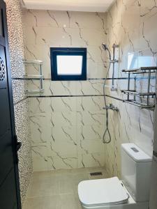 a bathroom with a toilet and a tv on the wall at Heart of Dakhla Residence in Dakhla +64 photos