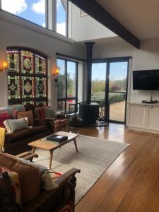 ein Wohnzimmer mit Sofa und Tisch in der Unterkunft The FatPonyLodge in Hepburn Springs