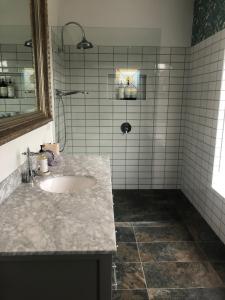 ein Bad mit einem Waschbecken und einer gefliesten Dusche in der Unterkunft The FatPonyLodge in Hepburn Springs + 35 Fotos