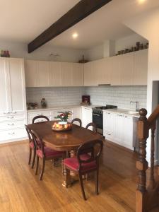 eine Küche mit einem Holztisch mit Stühlen und einem Tisch in der Unterkunft The FatPonyLodge in Hepburn Springs