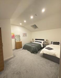 a bedroom with two beds and a dresser in it at Stylish Apartment in Bradford