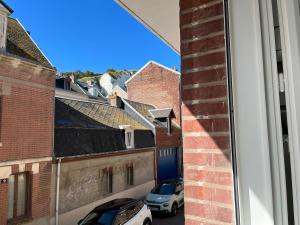 a view from a window of a street with parked cars at Les Orchidées 1 in Le Tréport