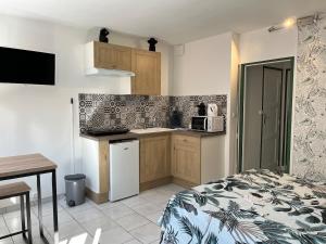 a small kitchen with a bed and a microwave at Les Orchidées 1 in Le Tréport