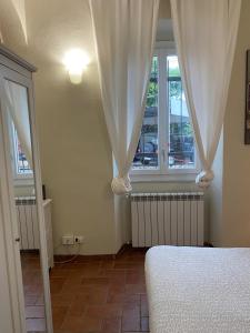 a bedroom with a bed and a window with curtains at La Pieve di Luca in La Spezia