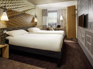 a hotel room with a large bed and a television at ibis Glasgow City Centre – Sauchiehall St in Glasgow