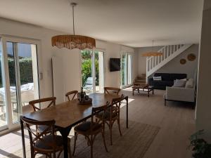 a dining room and living room with a table and chairs at La p'tite marquise in Roscoff