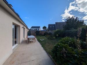 a small backyard with a table and a patio at La p'tite marquise in Roscoff