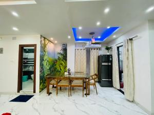 een eetkamer met een tafel en een blauw plafond bij The Metro Nest in Guwahati