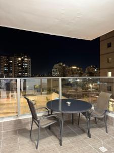 a table and chairs on a balcony with a view of a city at K Home 2 in Qiryat Gat