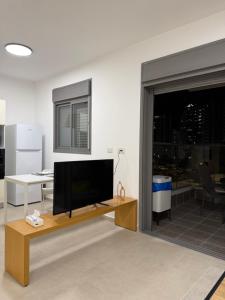 a living room with a flat screen tv on a table at K Home 2 in Qiryat Gat