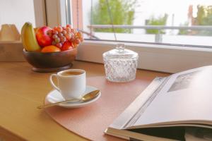 eine Tasse Kaffee und eine Schale Obst auf dem Tisch in der Unterkunft Oldtown in Trier + 4 Fotos