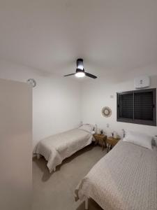 a bedroom with two beds and a ceiling fan at K Home 2 in Qiryat Gat