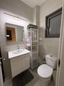 a bathroom with a white toilet and a sink at K Home 2 in Qiryat Gat +14 photos