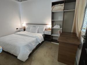 a small bedroom with a bed and a desk at Appart de Luxe à LAVERDA - à 400m de la plage in Dakhla