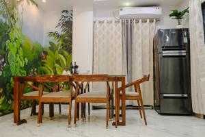een eetkamer met een tafel en stoelen en een koelkast bij The Metro Nest in Guwahati +10 foto's