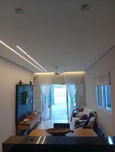 ein Wohnzimmer mit Sofa und Tisch in der Unterkunft Recanto Amora in Boicucanga