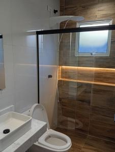 ein Badezimmer mit Dusche, Toilette und Waschbecken in der Unterkunft Recanto Amora in Boicucanga + 3 Fotos