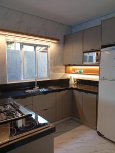 eine Küche mit einem weißen Kühlschrank und einer Spüle in der Unterkunft Recanto Amora in Boicucanga