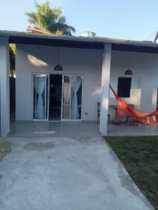 ein weißes Haus mit einer Hängematte davor in der Unterkunft Recanto Amora in Boicucanga
