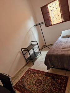 a bedroom with a bed and a rug and a window at House - Cantinho de Jacaré in Jacarèzinho