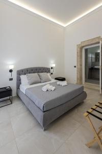a bedroom with a large bed with two towels on it at Dione Ortigia in Siracusa
