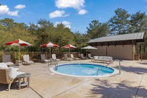 a pool with chairs and umbrellas on a patio at Redfish Village M2-329 in Blue Mountain Beach
