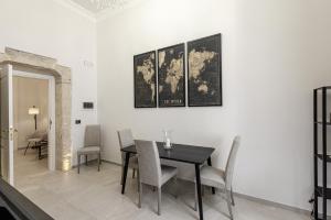 a dining room with a table and a map on the wall at Dione Ortigia in Siracusa +6 photos
