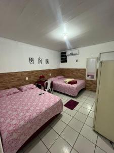 um quarto com duas camas e uma mesa em Pousada Carimbó em Fortaleza