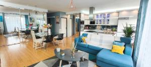 a living room with a blue couch and a kitchen at Appartement d'exception spacieux, 2 chambres, terrasse privée, vue Cathédrale imprenable in Strasbourg