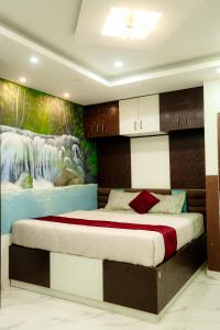 een slaapkamer met een groot bed met een schilderij aan de muur bij The Metro Nest in Guwahati