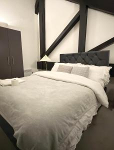 een slaapkamer met een groot bed met witte lakens bij Sampaul Bradford Apartment in Bradford