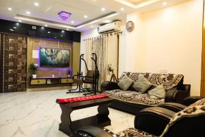 een woonkamer met een bank en een tv bij The Metro Nest in Guwahati