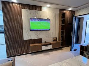a living room with a television on a wall at Appart de Luxe à LAVERDA - à 400m de la plage in Dakhla +3 photos