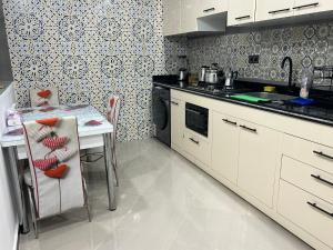 a kitchen with a table and a stove top oven at Appart de Luxe à LAVERDA - à 400m de la plage in Dakhla