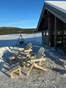 eine Sitzgruppe im Schnee vor einem Gebäude in der Unterkunft Cabin With Views In Langsua National Park in Heggenes