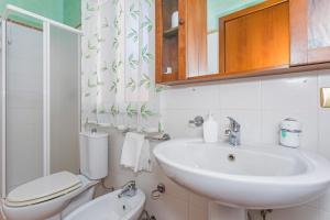 a white bathroom with a sink and a toilet at Casa Vacanze vicino Etna - Natura dell'Etna in Belpasso +23 photos