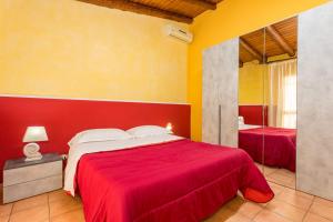 a bedroom with a red bed and a mirror at Casa Vacanze vicino Etna - Natura dell'Etna in Belpasso