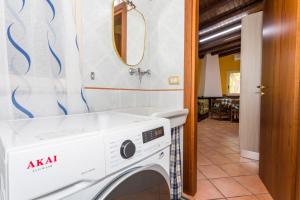 a washing machine in a bathroom with a mirror at Casa Vacanze vicino Etna - Natura dell'Etna in Belpasso