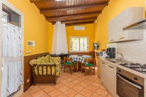 a kitchen with yellow walls and a table and chairs at Casa Vacanze vicino Etna - Natura dell'Etna in Belpasso