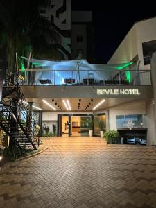 a large building with a staircase in front of it at Bevile Hotel in Cataguases